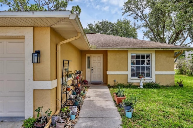 5823 Helen Way, Sarasota, FL 34243 - view of exterior entry with an attached garage, stucco siding, a lawn, and roof with shingles