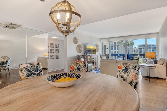 1115 Gulf Of Mexico Dr Unit 304, Longboat Key, FL 34228 - dining area with hardwood / wood-style floors, a chandelier, and baseboards