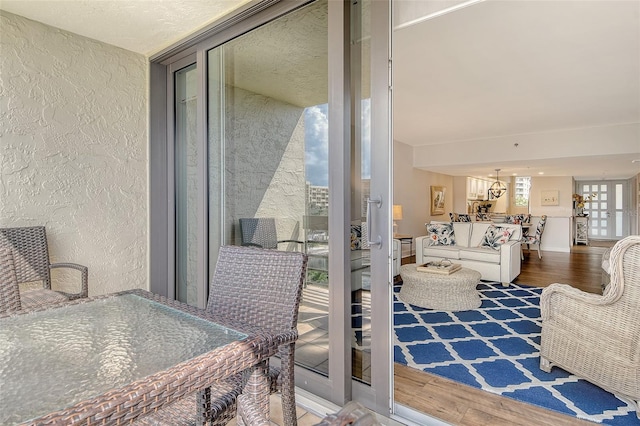 1115 Gulf Of Mexico Dr Unit 304, Longboat Key, FL 34228 - interior space with wood finished floors, a textured wall, a chandelier, and a wall of windows