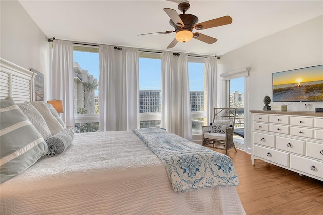 1115 Gulf Of Mexico Dr Unit 304, Longboat Key, FL 34228 - bedroom featuring wood finished floors, multiple windows, access to outside, and a ceiling fan