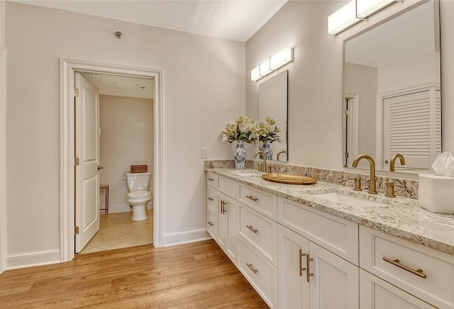 1115 Gulf Of Mexico Dr Unit 304, Longboat Key, FL 34228 - full bathroom featuring double vanity, toilet, wood finished floors, and baseboards