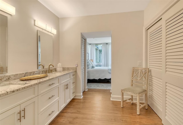1115 Gulf Of Mexico Dr Unit 304, Longboat Key, FL 34228 - full bathroom with double vanity, wood finished floors, ensuite bathroom, baseboards, and a closet