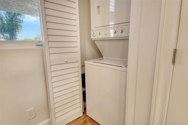 1115 Gulf Of Mexico Dr Unit 304, Longboat Key, FL 34228 - washroom with stacked washer and clothes dryer and light wood finished floors