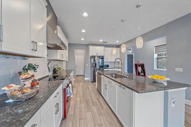 5191 78th St Cir E, Bradenton, FL 34203 - kitchen with a sink, wall chimney exhaust hood, appliances with stainless steel finishes, light wood-style flooring, and recessed lighting