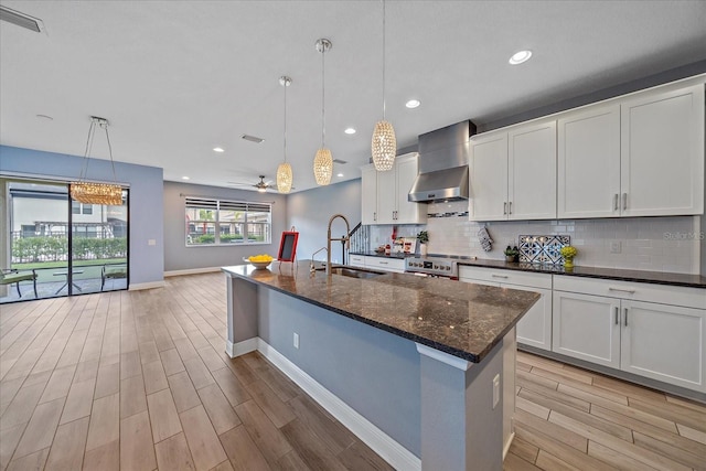 5191 78th St Cir E, Bradenton, FL 34203 - kitchen featuring a sink, wall chimney exhaust hood, light wood-type flooring, baseboards, and range
