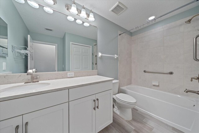 5191 78th St Cir E, Bradenton, FL 34203 - bathroom with shower / bath combination, toilet, vanity, wood finished floors, and a textured ceiling