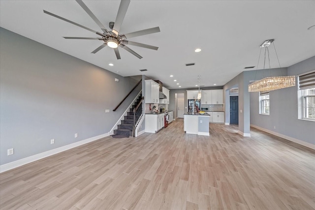5191 78th St Cir E, Bradenton, FL 34203 - unfurnished living room featuring stairs, light wood-style flooring, baseboards, a chandelier, and recessed lighting