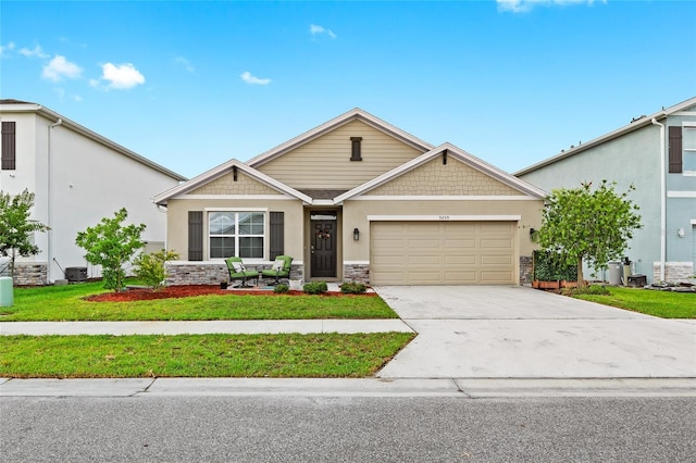 5659 Woodland Sage Dr, Sarasota, FL 34238 - craftsman-style house with stone siding, a garage, concrete driveway, a front yard, and stucco siding