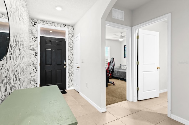 5659 Woodland Sage Dr, Sarasota, FL 34238 - entrance foyer featuring wallpapered walls, baseboards, arched walkways, light tile patterned floors, and ceiling fan