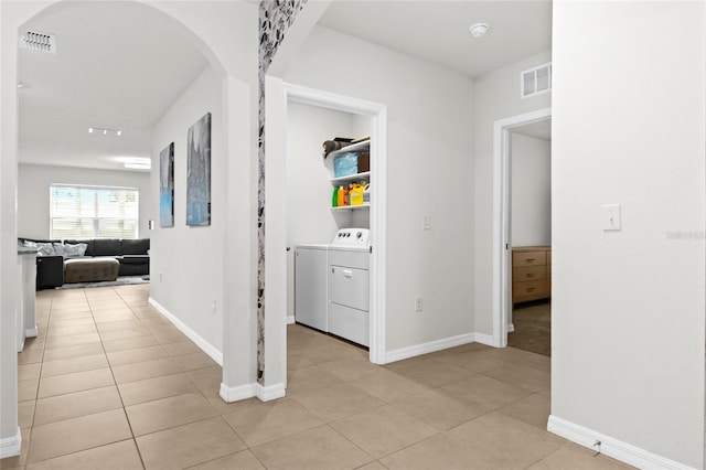 5659 Woodland Sage Dr, Sarasota, FL 34238 - hall with arched walkways, washing machine and clothes dryer, light tile patterned flooring, and baseboards