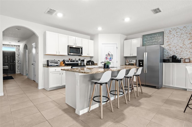 5659 Woodland Sage Dr, Sarasota, FL 34238 - kitchen featuring appliances with stainless steel finishes, an island with sink, white cabinets, and recessed lighting