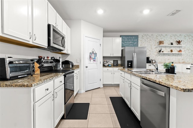5659 Woodland Sage Dr, Sarasota, FL 34238 - kitchen with appliances with stainless steel finishes, a sink, white cabinets, light tile patterned flooring, and light stone countertops