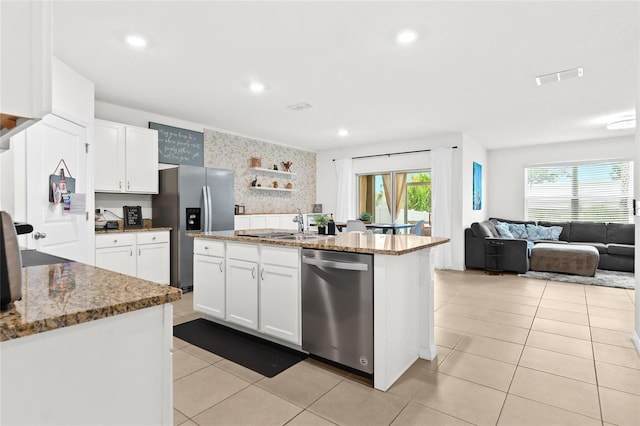 5659 Woodland Sage Dr, Sarasota, FL 34238 - kitchen with stainless steel appliances, a sink, light stone counters, light tile patterned floors, and white cabinets