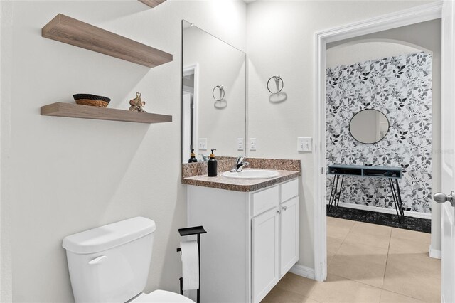 5659 Woodland Sage Dr, Sarasota, FL 34238 - bathroom featuring toilet, vanity, tile patterned floors, and baseboards