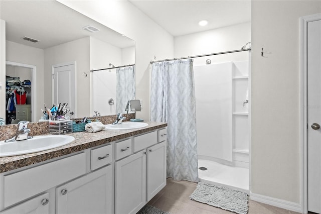 5659 Woodland Sage Dr, Sarasota, FL 34238 - full bathroom with a shower stall, double vanity, a walk in closet, and tile patterned flooring