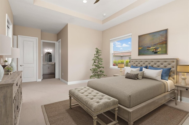 7508 Ripetta St, Sarasota, FL 34240 - bedroom featuring light colored carpet, baseboards, connected bathroom, and a tray ceiling
