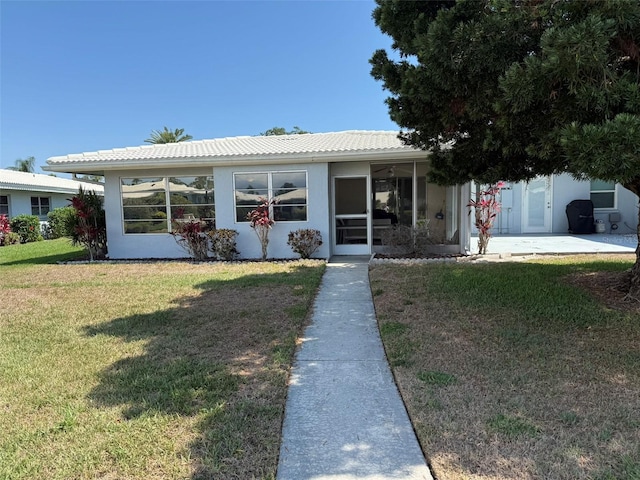3673 Somerville Dr Unit 1510, Sarasota, FL 34232 - view of front facade featuring a front yard, a tiled roof, stucco siding, and a sunroom