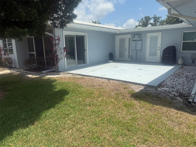 3673 Somerville Dr Unit 1510, Sarasota, FL 34232 - back of house with stucco siding, a yard, and a patio