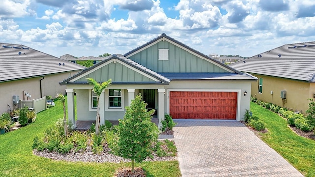 12743 Tahitian Pearl Cir, Parrish, FL 34219 - view of front facade featuring board and batten siding, decorative driveway, a porch, an attached garage, and a front lawn