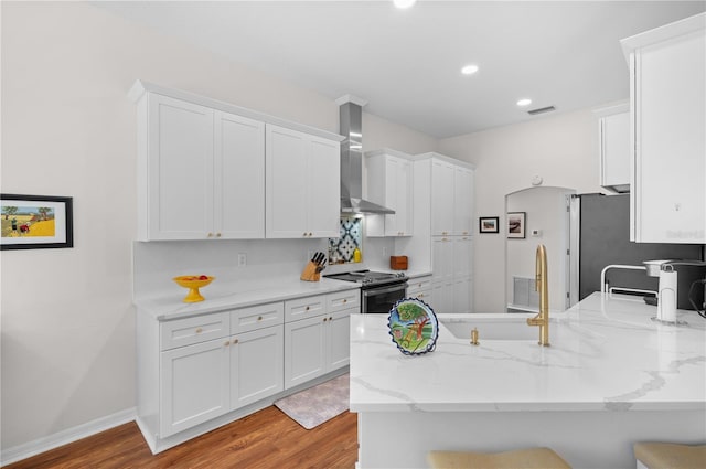 5110 19th Ave W, Bradenton, FL 34209 - kitchen with wall chimney range hood, appliances with stainless steel finishes, white cabinetry, a peninsula, and recessed lighting