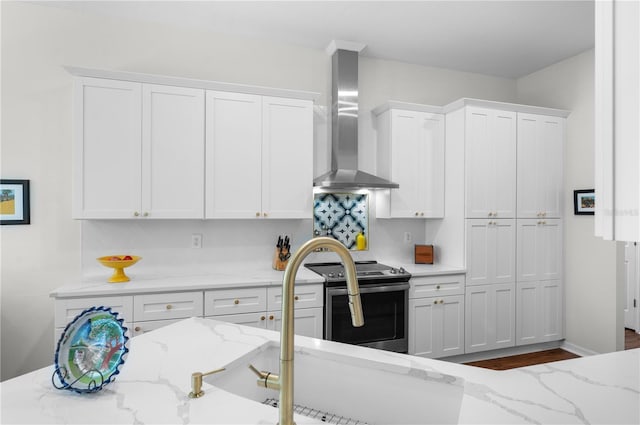 5110 19th Ave W, Bradenton, FL 34209 - kitchen featuring wall chimney exhaust hood, stainless steel range with electric stovetop, white cabinetry, and light stone counters