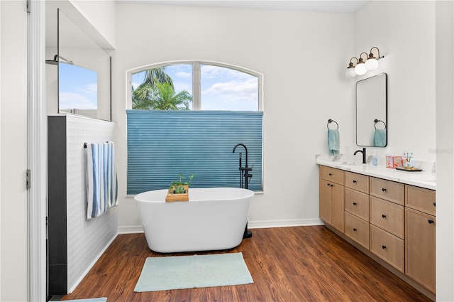 5110 19th Ave W, Bradenton, FL 34209 - full bathroom featuring double vanity, a soaking tub, baseboards, and wood finished floors