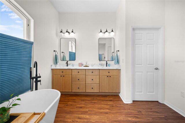5110 19th Ave W, Bradenton, FL 34209 - bathroom with a freestanding bath, double vanity, wood finished floors, and baseboards