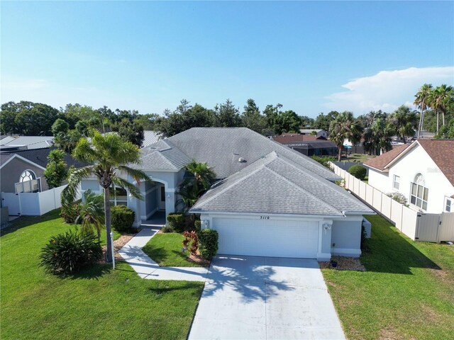 5110 19th Ave W, Bradenton, FL 34209 - view of front of property featuring a garage, driveway, a shingled roof, stucco siding, and a residential view