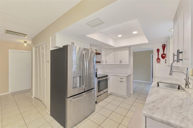 4155 Center Gate Blvd, Sarasota, FL 34233 - kitchen with appliances with stainless steel finishes, a sink, light tile patterned floors, white cabinetry, and recessed lighting