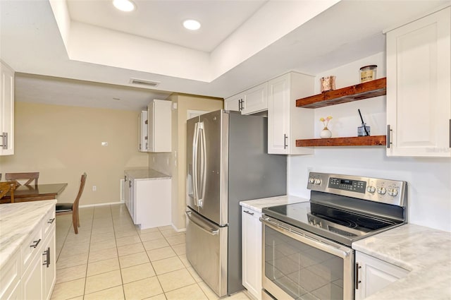 4155 Center Gate Blvd, Sarasota, FL 34233 - kitchen with stainless steel appliances, white cabinets, light tile patterned floors, and recessed lighting