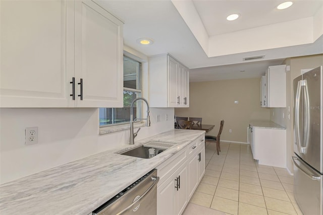 4155 Center Gate Blvd, Sarasota, FL 34233 - kitchen featuring appliances with stainless steel finishes, a sink, white cabinetry, light tile patterned floors, and baseboards