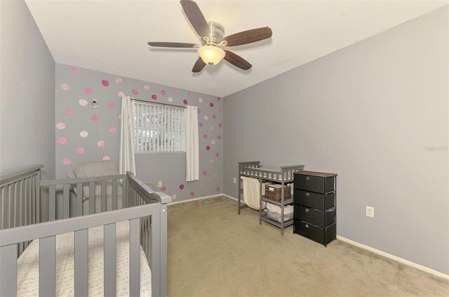 4155 Center Gate Blvd, Sarasota, FL 34233 - bedroom featuring light colored carpet, a crib, baseboards, and a ceiling fan