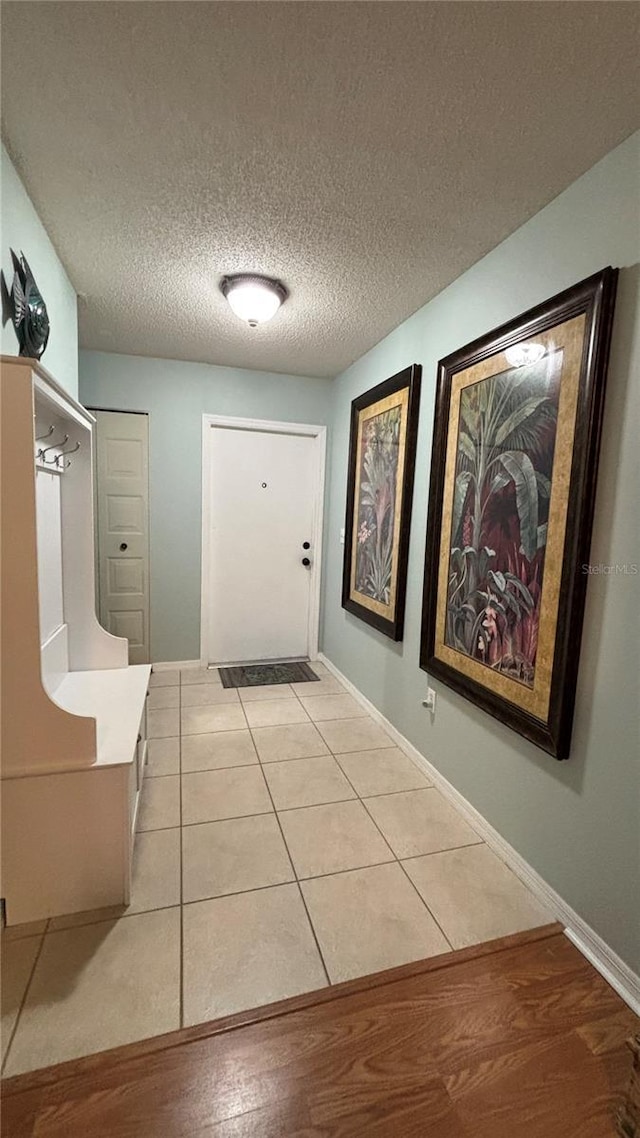 1111 Harefield Cir, Sun City Center, FL 33573 - hallway featuring baseboards, a textured ceiling, and light tile patterned floors