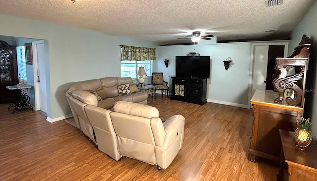 1111 Harefield Cir, Sun City Center, FL 33573 - living room with a textured ceiling, light wood-style floors, ceiling fan, and baseboards