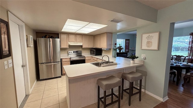 1111 Harefield Cir, Sun City Center, FL 33573 - kitchen with stainless steel appliances, a sink, under cabinet range hood, light countertops, and a peninsula