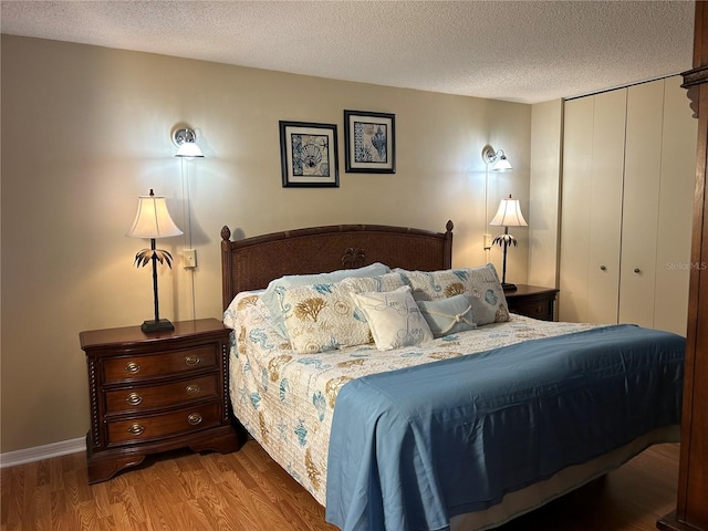 1111 Harefield Cir, Sun City Center, FL 33573 - bedroom featuring wood finished floors, a textured ceiling, and a closet