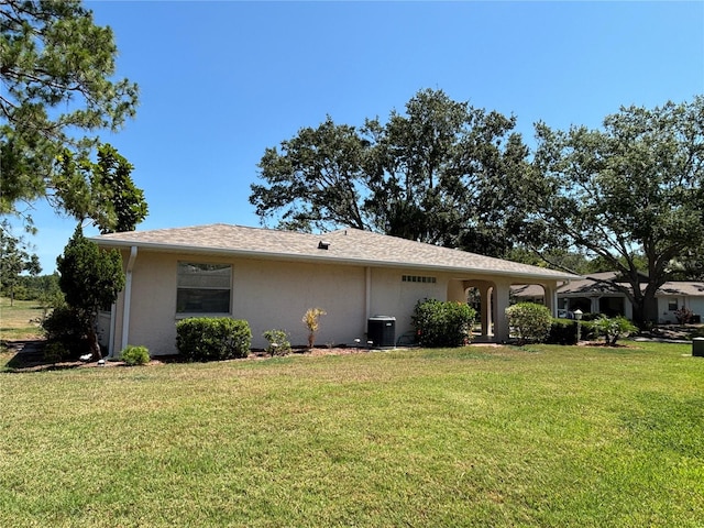 1111 Harefield Cir, Sun City Center, FL 33573 - rear view of house featuring central air condition unit, a yard, and stucco siding