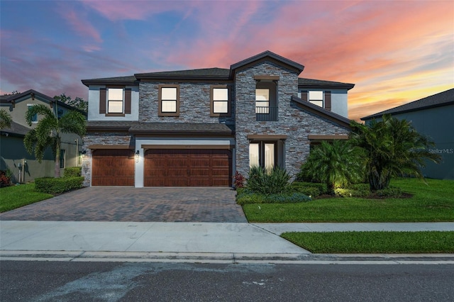 8932 Isabella Cir, Parrish, FL 34219 - view of front of house with an attached garage, decorative driveway, stone siding, stucco siding, and a yard