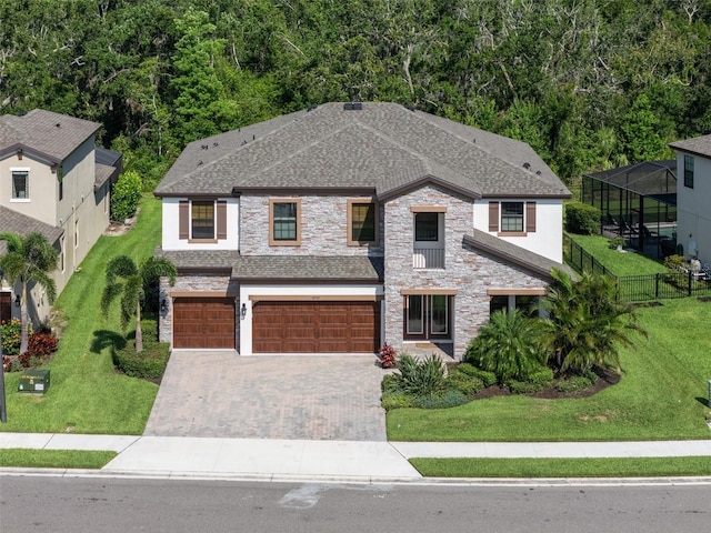 8932 Isabella Cir, Parrish, FL 34219 - view of front facade with an attached garage, stone siding, driveway, a shingled roof, and stucco siding