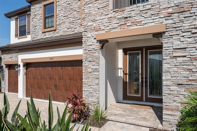8932 Isabella Cir, Parrish, FL 34219 - entrance to property featuring stone siding, a garage, and stucco siding