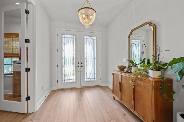 8932 Isabella Cir, Parrish, FL 34219 - entrance foyer with french doors, a chandelier, light wood-style floors, and baseboards