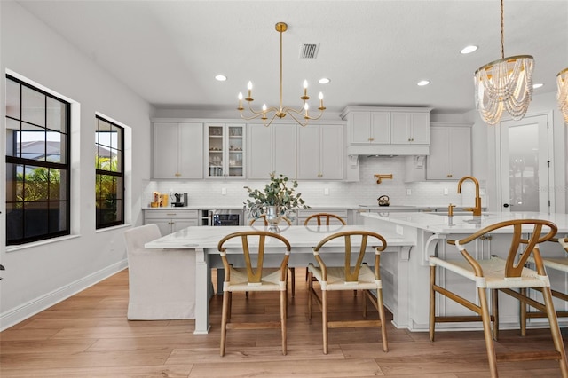 8932 Isabella Cir, Parrish, FL 34219 - kitchen with a chandelier, a sink, a breakfast bar, recessed lighting, and backsplash