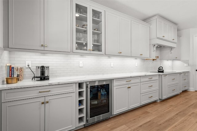 8932 Isabella Cir, Parrish, FL 34219 - bar featuring beverage cooler, tasteful backsplash, black electric cooktop, and light wood-type flooring