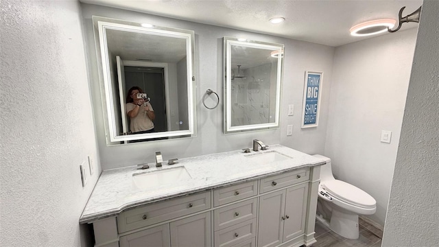 6400 46th Ave N Unit 113, Kenneth City, FL 33709 - full bath with toilet, double vanity, a textured wall, and a shower