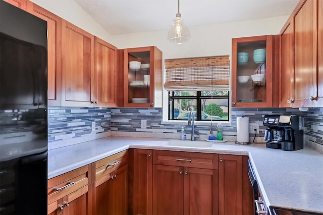 2906 63rd St W Unit 206, Bradenton, FL 34209 - kitchen with freestanding refrigerator, a sink, backsplash, decorative light fixtures, and brown cabinets