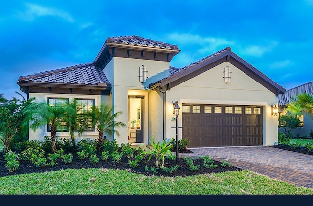 26687 Raphis Royale Blvd, Englewood, FL 34223 - mediterranean / spanish house featuring an attached garage, stucco siding, driveway, and a tiled roof