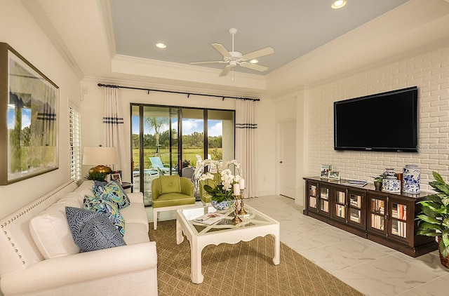 26687 Raphis Royale Blvd, Englewood, FL 34223 - living room with ceiling fan, ornamental molding, recessed lighting, light marble finish flooring, and a raised ceiling
