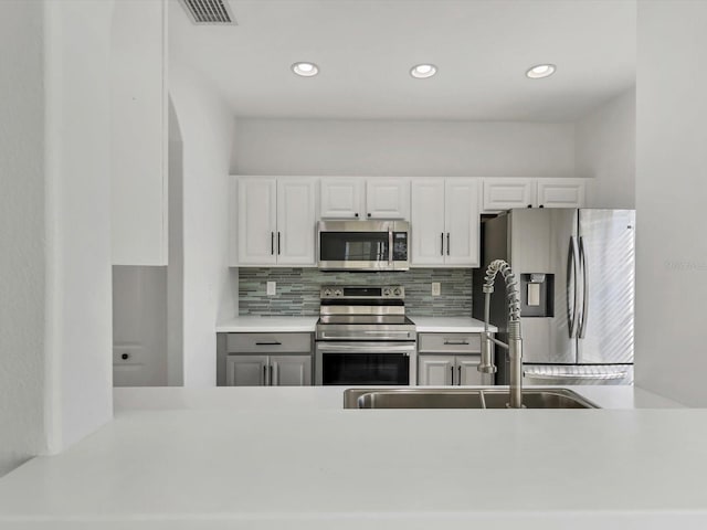 262 Cape Harbour Loop Unit 101, Bradenton, FL 34212 - kitchen featuring stainless steel appliances, tasteful backsplash, light countertops, white cabinetry, and recessed lighting