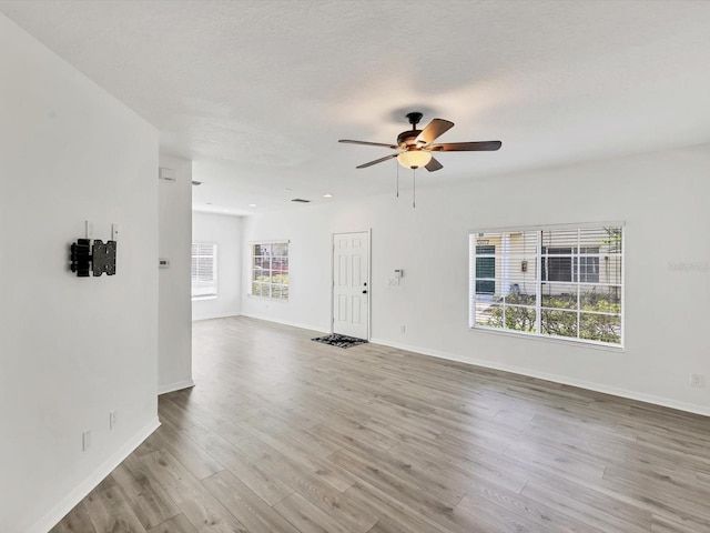 262 Cape Harbour Loop Unit 101, Bradenton, FL 34212 - unfurnished living room featuring ceiling fan, wood finished floors, and baseboards