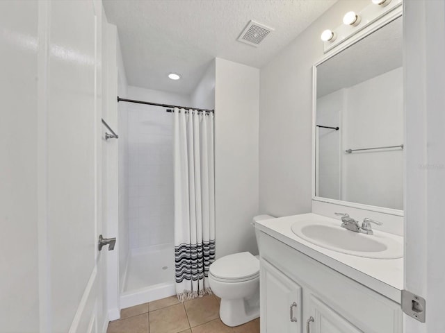 262 Cape Harbour Loop Unit 101, Bradenton, FL 34212 - full bath with vanity, toilet, tile patterned floors, a tile shower, and a textured ceiling